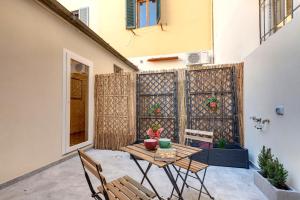 Un patio con mesa y sillas y una valla. en Civico 5 Florence - Silenzioso appartamento nel cuore di Firenze San Lorenzo, en Florencia