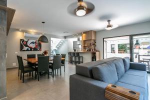 a living room with a blue couch and a dining room at Casa perfeita pro verão e inverno na Riviera in Bertioga
