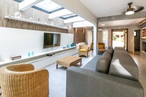 a living room with a couch and a tv at Casa perfeita pro verão e inverno na Riviera in Bertioga