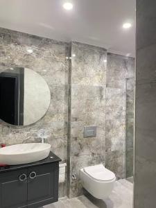 La salle de bains est pourvue d'un lavabo, de toilettes et d'un miroir. dans l'établissement Villa Blue - New Luxury Villa, à Belek