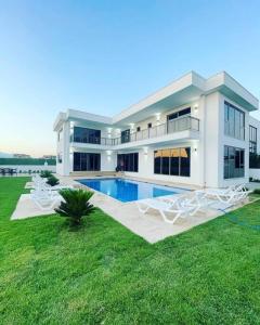 une grande maison avec une piscine dans une cour dans l'établissement Villa Blue - New Luxury Villa, à Belek