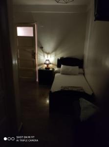 a bedroom with a bed and a door with a light at Salvatore Rooms with Breakfast-City Center in Dumyāţ