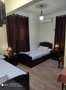 een slaapkamer met 2 bedden en 2 lampen erin bij Salvatore Rooms with Breakfast-City Center in Damietta