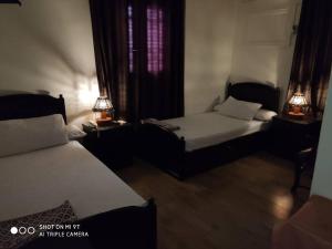 een slaapkamer met 2 bedden en 2 lampen op tafels bij Salvatore Rooms with Breakfast-City Center in Damietta