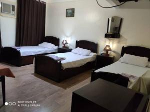 a hotel room with two beds and a tv at Salvatore Rooms with Breakfast-City Center in Dumyāţ