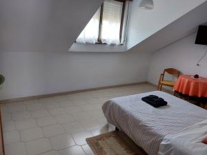 a bedroom with a bed and a table and a window at Pensión El Pozo in Cudillero