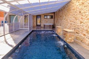 een groot zwembad met water in een kamer bij Apartamentos & Wellnes LA QUIMERA DE AITANA Burgo de Osma in El Burgo de Osma