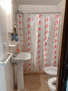 baño con cortina de ducha con peces rojos en Los colibríes en Concepción del Uruguay