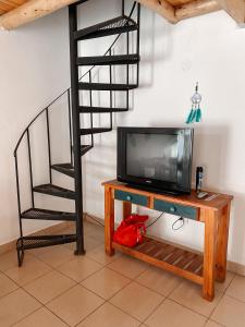un televisor sentado en la parte superior de una mesa junto a una escalera en Los colibríes en Concepción del Uruguay