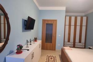 a bedroom with a bed and a sink and a mirror at Domi Apartment in Durrës