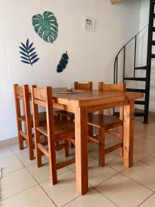 烏拉圭河畔康塞普西翁的住宿－Los colibríes，木餐桌和挂在墙上的植物椅子