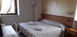 a bedroom with a bed with two towels on it at Le Bottesele in San Zeno di Montagna