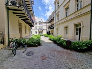 a bike parked on a brick walkway between two buildings at Apartamenty Sebastiana in Kraków