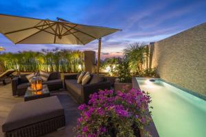 a patio with a couch and an umbrella next to a pool at Jose Antonio Deluxe in Lima