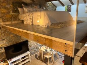 Habitación con cama, TV y mesa. en Casa Rural Vivienda Vacacional L´Andolina Complejo CaleaCabo, en Biescas
