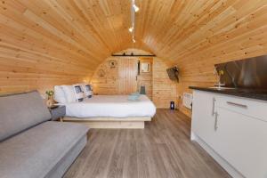 a bedroom with a bed in a wooden cabin at Little Meadow Pods with Hot Tub in York