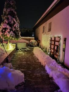 a snow covered path next to a building with lights at Wellnessoase Nordschwarzwald in Neuweiler
