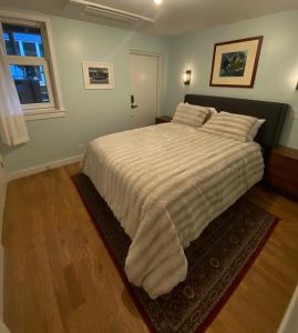 una camera da letto con un grande letto con una coperta bianca di Cozy Garden Apt in Williamsburg NYC Townhouse a Brooklyn