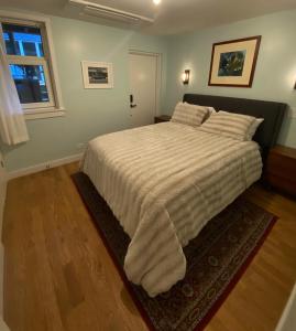 a bedroom with a large bed with a white blanket at Cozy Garden Apt in Williamsburg NYC Townhouse in Brooklyn