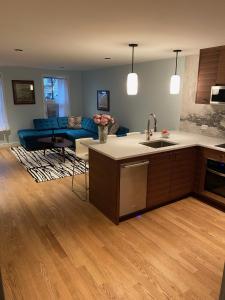 a kitchen and living room with a sink and a couch at Cozy Garden Apt in Williamsburg NYC Townhouse in Brooklyn