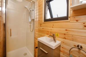 a bathroom with a sink and a shower and a toilet at Little Meadow Pods with Hot Tub in York