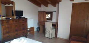 1 dormitorio con 1 cama, vestidor y escritorio con TV en Le Bottesele, en San Zeno di Montagna
