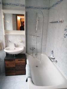 a bathroom with a tub and a sink and a shower at Magnifique Appartement Cosy in Chateau-d'Oex