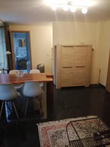 a kitchen with a wooden table and a refrigerator at Magnifique Appartement Cosy in Chateau-d'Oex