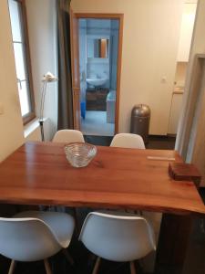 a dining room table with white chairs around it at Magnifique Appartement Cosy in Chateau-d'Oex