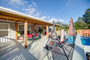 a house with a deck with a pool and a umbrella at Moore Haven Getaway with Deck and Private Pool in Moore Haven