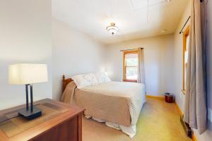 a bedroom with a bed and a table with a lamp at Let's Bay Together in Ossipee