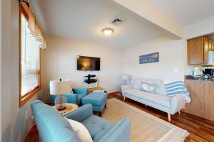 a living room with blue couches and a tv at Let's Bay Together in Ossipee