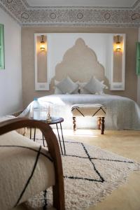 a bedroom with a large bed and a table at Riad Chic in Marrakesh