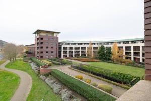 a building with a garden in front of a building at Luxury 2 bed, Central, Free Parking, Smart TV By Valore Property Services in Milton Keynes