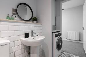 a white bathroom with a sink and a mirror at Luxury 2 bed, Central, Free Parking, Smart TV By Valore Property Services in Milton Keynes