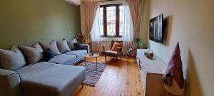 een woonkamer met een bank en een tafel bij Top Central 2 Bedroom Apartment next to NDK in Sofia