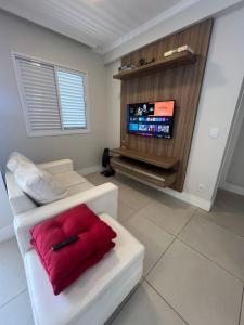 a living room with a white couch and a flat screen tv at Apto próximo ao Estádio Morumbi in Sao Paulo