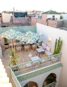 a balcony with an umbrella and a table and chairs at Riad Chic in Marrakesh