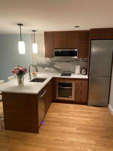 a kitchen with wooden cabinets and stainless steel appliances at Cozy Garden Apt in Williamsburg NYC Townhouse in Brooklyn