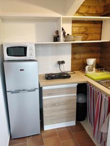 una piccola cucina con frigorifero bianco e forno a microonde di Bungalow Paradis Antillais (Do#) à moins de 10mn à pieds des plages a Le Gosier