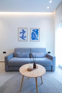 a living room with a blue couch and a table at CLIC suite and family in Ioannina