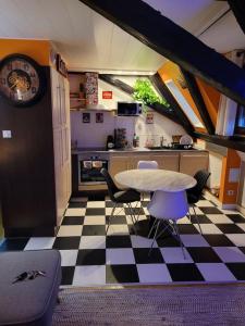 - une cuisine avec une table et des chaises sur un sol en damier dans l'établissement Appartement Atypique, à Soultz-Haut-Rhin