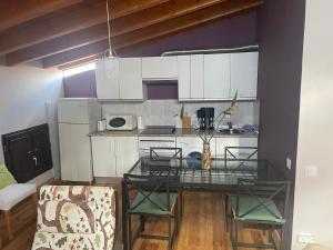 cocina con mesa de cristal en una habitación en Ático aires de gredos, en Candeleda