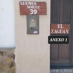 een bord aan de zijkant van een gebouw naast een deur bij EL ZAGUAN ANEXO I in Cafayate
