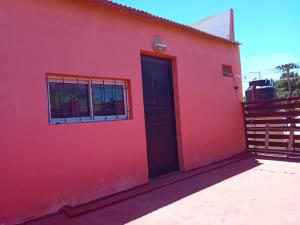 阿肖海la positiva 2的一间红色的房子,有黑色的门和栅栏