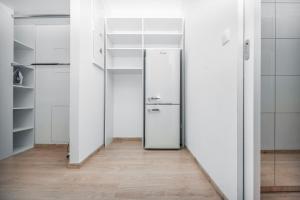 a walk in closet with a refrigerator and shelves at City Center Apartment - Modern & Elegant in Bratislava