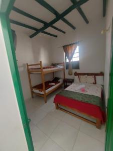 een kleine slaapkamer met een bed en een raam bij POSADA CASA MIA in Villa de Leyva
