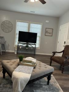 a living room with a couch and a flat screen tv at Favored Stay in Savannah