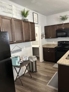 a kitchen with wooden cabinets and a black refrigerator at Favored Stay in Savannah