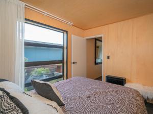 Un pat sau paturi într-o cameră la The Front Deckhouse - Whangamata Holiday Home